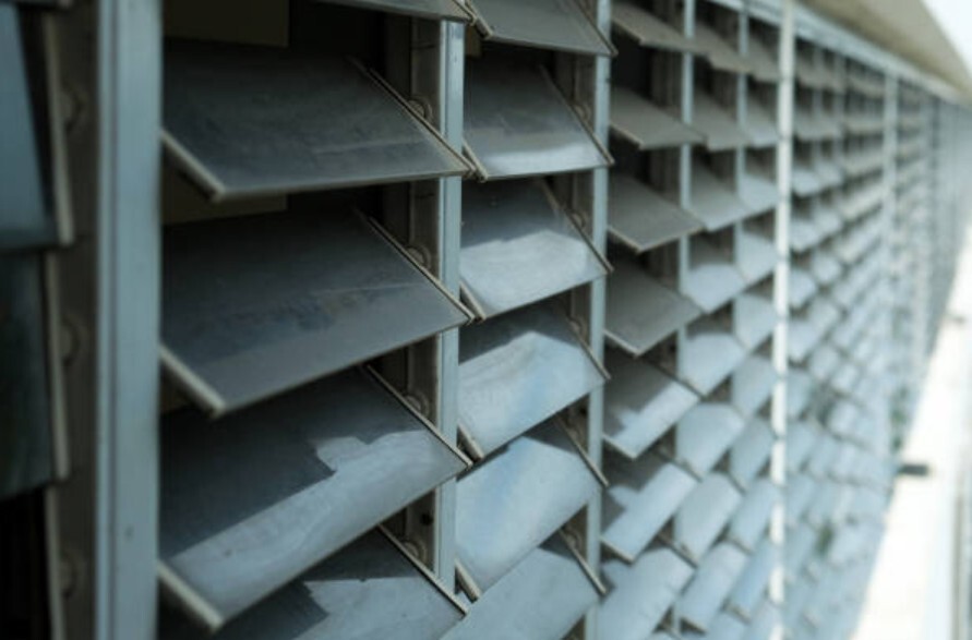 Close-up view of metal ventilation louvers on a building exterior.