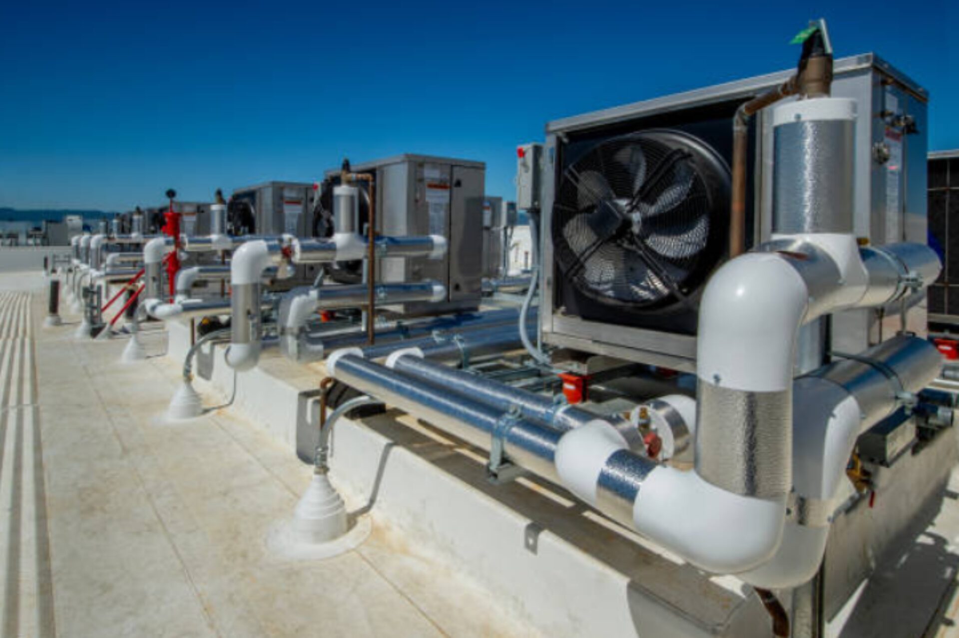 Rooftop mechanical ventilation system with large industrial fans and ductwork.